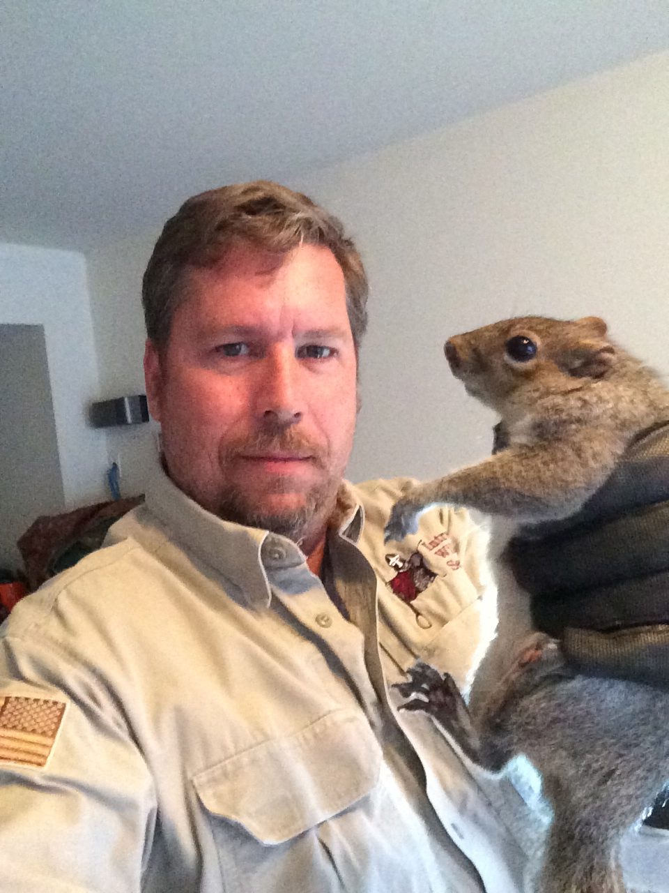 Man holding a squirrel indoors