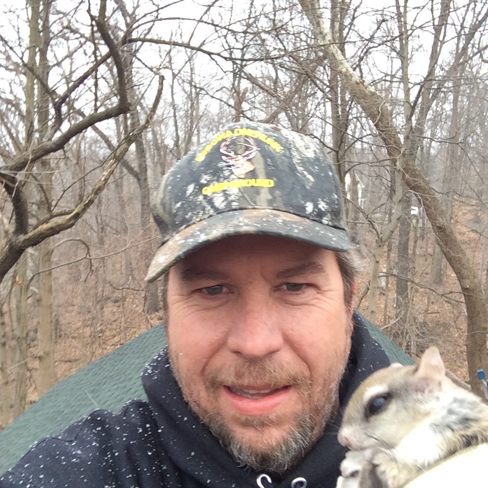 Man holding a small animal outdoors